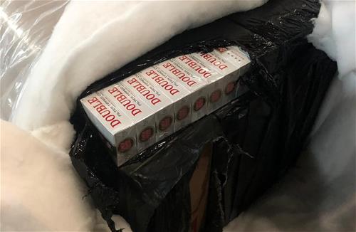 Assorted duty-unpaid cigarettes, wrapped in black trash bags