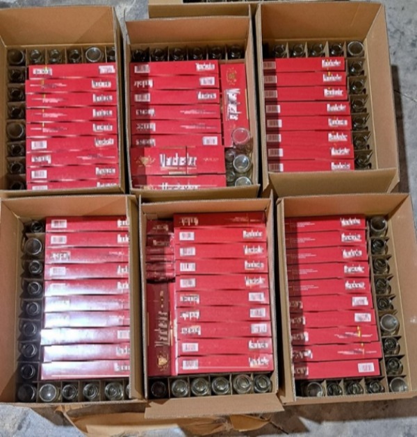 Photo (ICA): Duty-unpaid cigarettes concealed inside cardboard boxes containing glass jars.