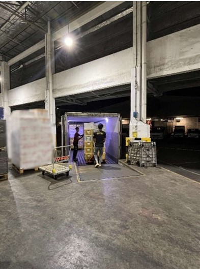 Truck drivers unloading imports for inspection